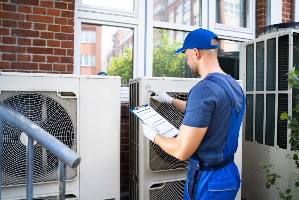 HVAC technician inspecting outdoor air conditioner cabinet in Lower Clinton Hill, Newark.